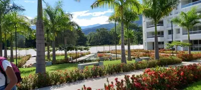 a building with a garden with flowers and palm trees at Santafé Di sole in Santa Fe de Antioquia