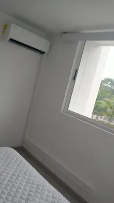 a white bedroom with a window and a bed at Santafé Di sole in Santa Fe de Antioquia