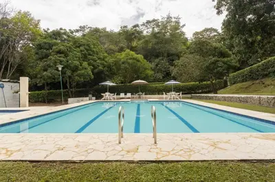 a swimming pool with chairs and umbrellas in a yard at Finca La Maria: Recreo y naturaleza (22 personas) in Santa Fe de Antioquia
