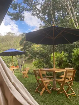 a table and chairs with an umbrella and a hammock at Finca La Maria: Recreo y naturaleza (22 personas) in Santa Fe de Antioquia