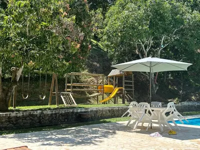 a table and chairs with an umbrella next to a pool at Finca La Maria: Recreo y naturaleza (22 personas) in Santa Fe de Antioquia