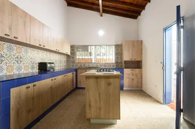 a kitchen with wooden cabinets and a blue counter top at Finca La Maria: Recreo y naturaleza (22 personas) in Santa Fe de Antioquia