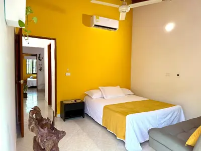 a bedroom with a bed and a yellow wall at Sol Apartamentos Doradal in Doradal