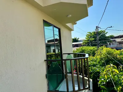 a balcony with a window with a chair on it at Sol Apartamentos Doradal in Doradal
