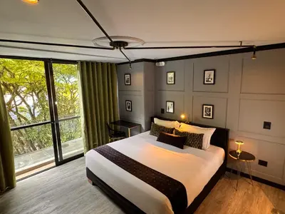 a bedroom with a large bed and a large window at Hotel Helene in Medellín