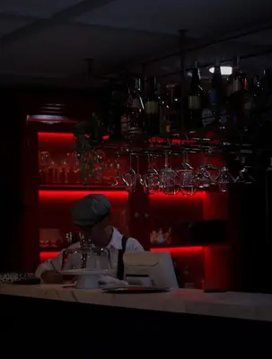 a man sitting at a table in a bar with a laptop at Hotel Helene in Medellín