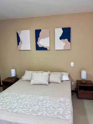 a bedroom with a bed with four pictures on the wall at Apartamento Completo Poblado - Ubicacion Central con Parqueadero in Medellín