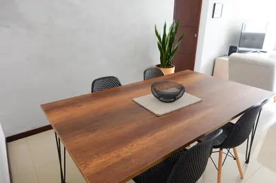 a dining room table with chairs and a hat on it at Apartamento Completo Poblado - Ubicacion Central con Parqueadero in Medellín