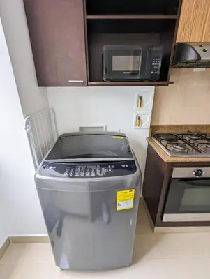 a small kitchen with a stove and a microwave at Apartamento Completo Poblado - Ubicacion Central con Parqueadero in Medellín
