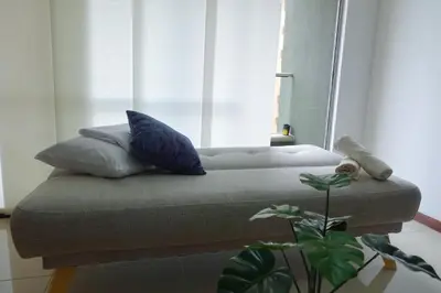 a couch with pillows sitting in front of a window at Apartamento Completo Poblado - Ubicacion Central con Parqueadero in Medellín