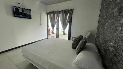 a bedroom with a white bed with a window at Los Potrillos in Mariquita