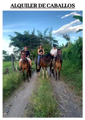 a group of people riding horses down a dirt road at Los Potrillos in Mariquita