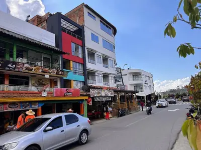 a silver car driving down a city street with buildings at Apto frente al Malecón, Ubicación fantástica, Vista in Guatapé