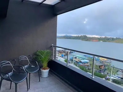 a balcony with chairs and a view of the water at Apto frente al Malecón, Ubicación fantástica, Vista in Guatapé