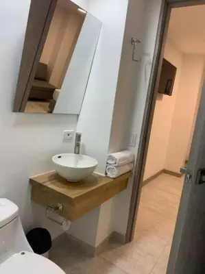 a bathroom with a sink and a toilet and a mirror at Apto frente al Malecón, Ubicación fantástica, Vista in Guatapé
