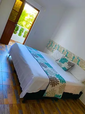 a bed in a room with a window at Hotel Santa Fe del Parque in Santa Fe de Antioquia