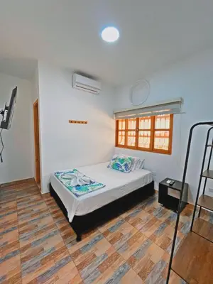 a bedroom with a bed and a wooden floor at Hotel Santa Fe del Parque in Santa Fe de Antioquia