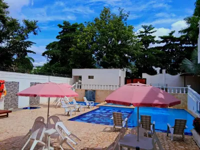 a pool with tables and chairs and umbrellas at Hotel Santa Fe del Parque in Santa Fe de Antioquia