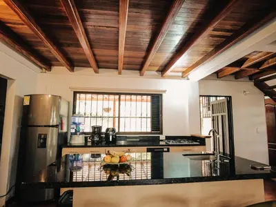 a kitchen with a black counter top and wooden ceilings at Volare Guatapé isla de descanso y retiro in Guatapé