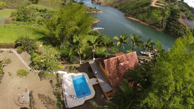 an aerial view of a resort with a pool and a river at Volare Guatapé isla de descanso y retiro in Guatapé