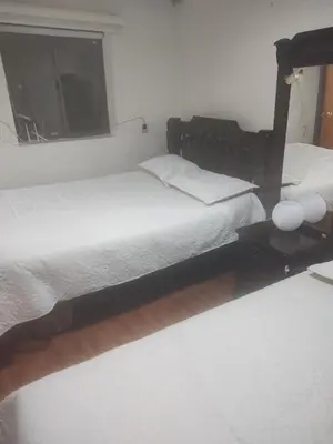 a bedroom with two beds and a window at Nora's Casa de familia Laureles in Medellín
