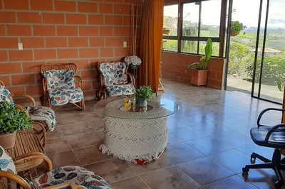 a patio with chairs and a table in a room at Casa de Campo vía El Peñol Guatapé in Marinilla