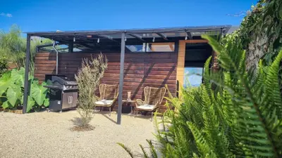 a house with two chairs and a grill in a yard at Cumbres Luxury Glamping in Guarne