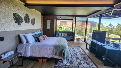 a bedroom with a bed and a flat screen tv at Cumbres Luxury Glamping in Guarne