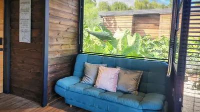 a blue couch with two pillows on a porch at Cumbres Luxury Glamping in Guarne
