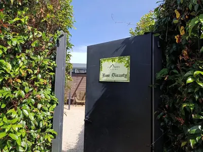 a black gate with a sign on it next to a hedge at Cumbres Luxury Glamping in Guarne