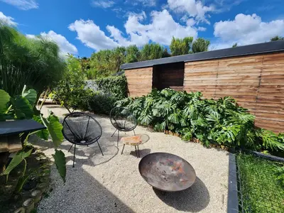 a garden with two chairs and a rusty metal object at Cumbres Luxury Glamping in Guarne