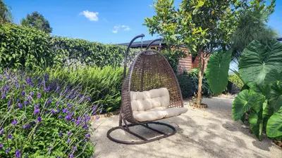a rattan chair sitting in the middle of a garden at Cumbres Luxury Glamping in Guarne