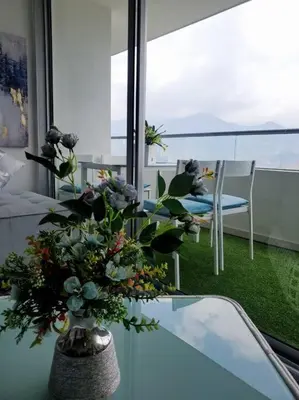a vase with flowers on a table in a room at Penthouse Lujo Itagui 40 Piso Vista Panoramica Jacuzzi Sauna Largo Plazo in Itagüí