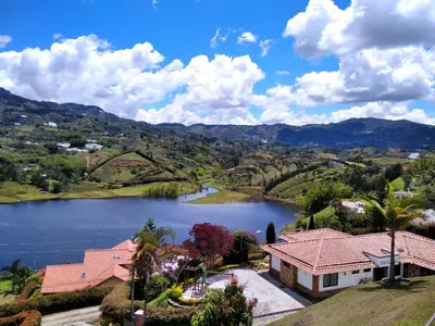 a house with a view of a lake at Cottage Master Room en Guatapé-Desayuno- Sauna Finlandes in Chiquinquirá