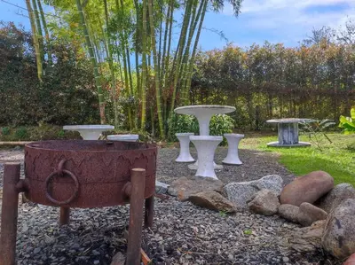 a garden with two picnic tables and a fire pit at Cottage Master Room en Guatapé-Desayuno- Sauna Finlandes in Chiquinquirá