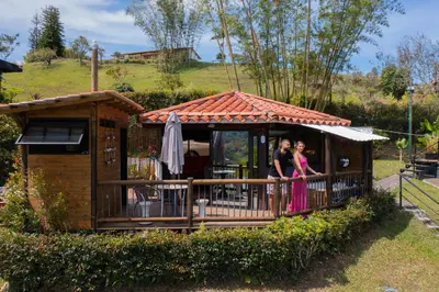 two women standing on the porch of a tiny house at Cottage Master Room en Guatapé-Desayuno- Sauna Finlandes in Chiquinquirá
