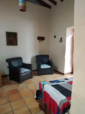 a room with two chairs and a bed in a room at Recinto Alfaro in Concepción