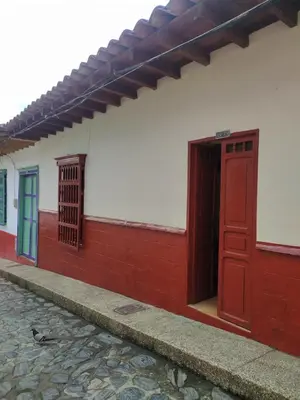 a red and white building with a red door and a sidewalk at Recinto Alfaro in Concepción