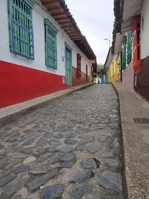 a cobblestone street with colorful buildings and windows at Recinto Alfaro in Concepción