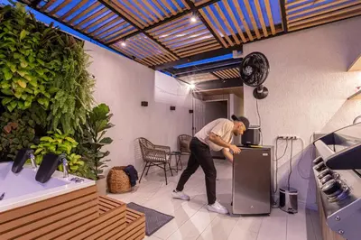 a man leaning on a refrigerator in a room at Jacuzzi Privado, Casa de Lujo Norte Medellin in Medellín