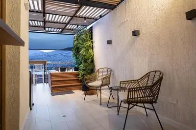 a patio with chairs and a balcony with a view at Jacuzzi Privado, Casa de Lujo Norte Medellin in Medellín