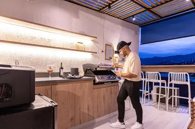 a man standing at a counter in a kitchen at Jacuzzi Privado, Casa de Lujo Norte Medellin in Medellín