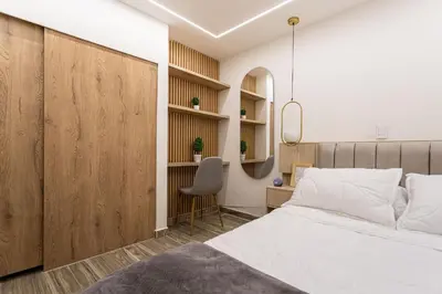 a bedroom with a bed and a desk and a chair at Cozy Apartment with A/C in North Medellin. in Medellín