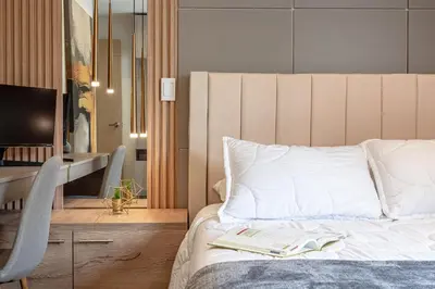 a bedroom with a bed with a book and a desk at Cozy Apartment with A/C in North Medellin. in Medellín