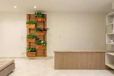 a living room with potted plants on the wall at Cozy Apartment with A/C in North Medellin. in Medellín