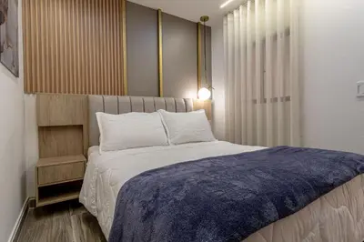 a bedroom with a bed with a blue blanket on it at Cozy Apartment with A/C in North Medellin. in Medellín