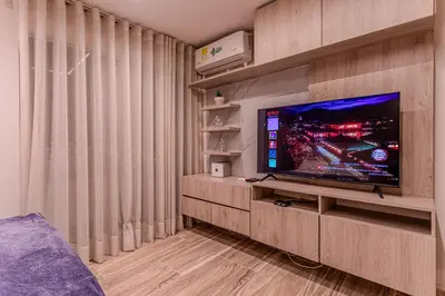 a living room with a flat screen tv on a entertainment center at Cozy Apartment with A/C in North Medellin. in Medellín