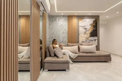a woman sitting on a couch in a room at Cozy Apartment with A/C in North Medellin. in Medellín