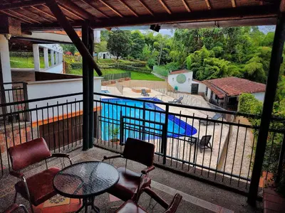 a balcony with a table and chairs and a swimming pool at Gran Tierra - Sabaneta in Medellín