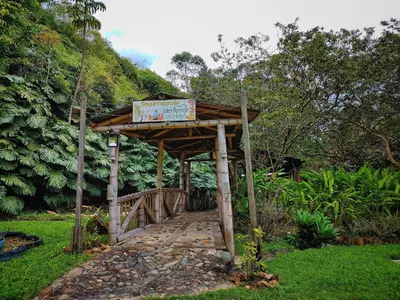 a sign on a wooden bridge in the grass at Gran Tierra - Sabaneta in Medellín
